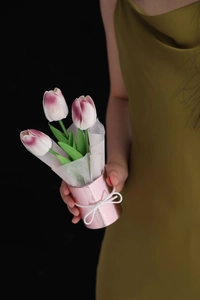 Close-up of three pink and purple PU tulips in a metallic pink bucket with a bow