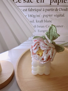 Close-up of handmade crochet peony bouquet in a bubble vase on a wooden tray decor