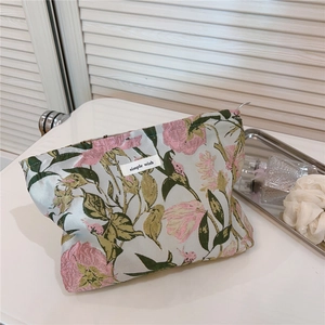 Detailed shot of floral jacquard makeup bag with metal zipper and simple wish woven label