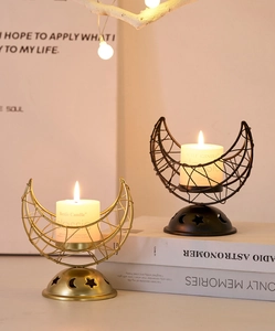 Detail of moon-shaped metal incense burner with star cutouts in gold and black finishes