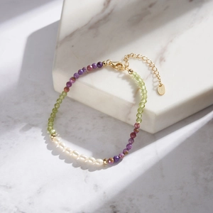 Detail of multi-color gemstone and freshwater pearl bracelet with S925 golden clasp