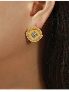 Detailaufnahme eines vergoldeten Vintage-Ohrrings mit quadratischem Zirkonstein an einem Model