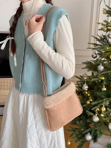 Sac bandoulière marron en suédine et peluche dans un décor de Noël festif et élégant