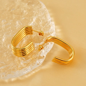 Gold multi-layer U-shaped hoop earrings with four parallel lines on textured glass