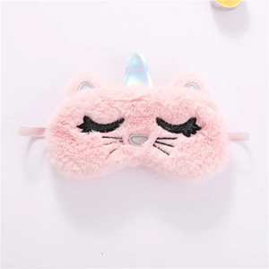 Detail of pink plush sleeping mask with unicorn horn and embroidered cat eyelashes