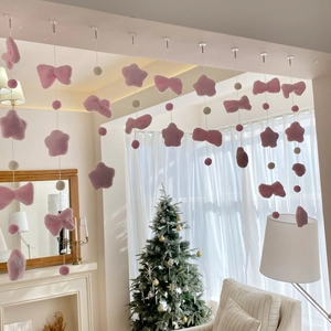 Detailed view of pink plush curtain with star and bow accents for wall decoration