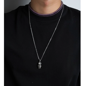Detail of silver astronaut pendant featuring a polished visor and a classic cross chain