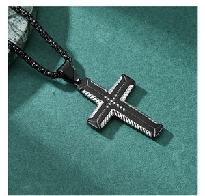 Macro shot of hip hop cross pendant with black crystals on textured green suede