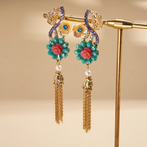 Détail de boucles d'oreilles vintage avec fleurs en résine et longues franges dorées