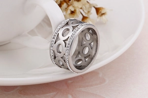 Detailed macro view of a silver hollow-out infinity ring with two rows of cubic zirconia