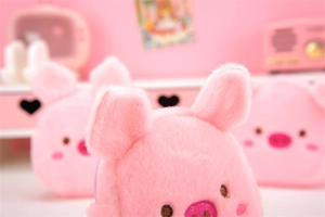Close-up of soft pink plush pig coin purse with fluffy texture in cozy setting