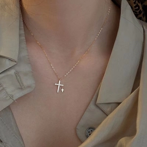 Detalle de collar dorado con colgantes de doble cruz de circón brillante en modelo
