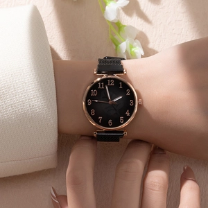 Detail of elegant black dial watch with rose gold numbers and magnetic mesh strap