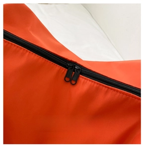Detail of smooth double black zippers on bright orange waterproof oxford fabric bag