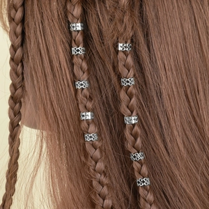 Détail de bagues de cheveux argentées évidées aux motifs vintage sur des tresses