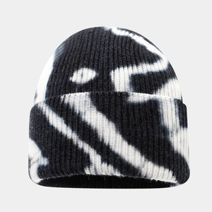 Detailed close-up of a black and white tie-dye ribbed knit beanie with cuffed edge