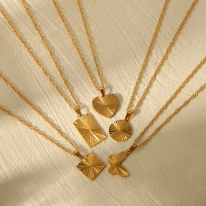 Set of five gold titanium steel necklaces with textured heart and geometric pendants