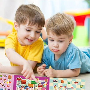 Two young boys playing with reusable dinosaur and ocean themed sticker activity books