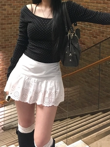 Mini-jupe en dentelle blanche évidée à bords festonnés et haut noir à pois blancs