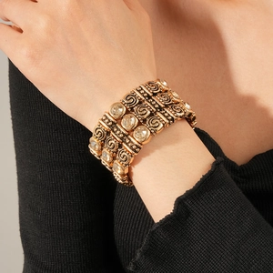 Detail of vintage gold-plated four-row elastic bracelet with rhinestones and spiral texture