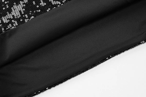 Gros plan sur le tissu à paillettes noires d'une robe moulante sexy aux détails brillants