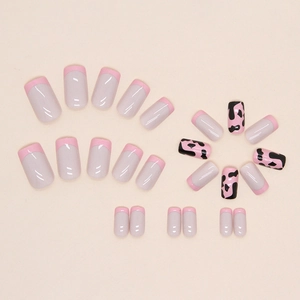 Faux ongles carrés rose French avec motifs de vache noir et rose sur fond beige