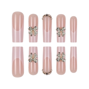 French press-on nails with silver 3D bows and rhinestones on nude pink base