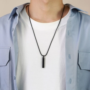 Minimalist black tungsten steel bar pendant necklace worn by a male model over a white T-shirt