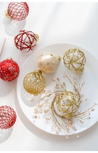 Detailed view of 6cm PET Christmas balls with red and gold patterns on a tray