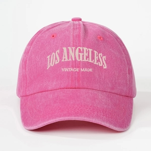 Detail of white Los Angeles embroidery on vintage washed pink cotton baseball cap