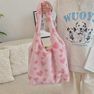 Close-up of pink plush tote bag with heart patterns and soft faux fur texture