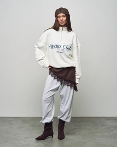 Detailed full-body view of oversized white half-zip sweatshirt and grey jogger set