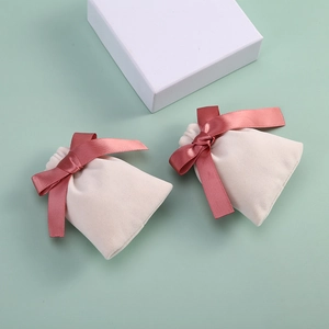 Detailed shot of velvet jewelry pouches with elegant pink satin ribbon bow closure
