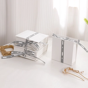 Elegant white jewelry gift boxes with black Best Wishes ribbons and decorative accents
