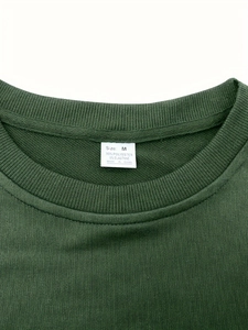 Détail du col d'un t-shirt vert avec étiquette d'entretien et infos matières