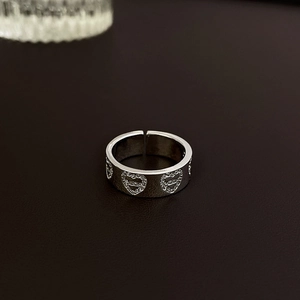 Macro shot of silver bow heart open ring featuring hollowed patterns with cubic zirconia