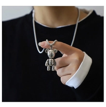 Detail of silver bear pendant necklace on model showcasing the high-quality steel texture