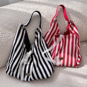 Détails de sacs cabas en toile rayée avec bordure en dentelle et logo métallique chic