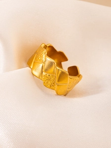Detailed close-up of a wide vintage 18k gold-plated ring with baroque relief patterns
