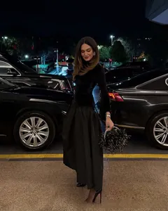 Détail d'une élégante robe de soirée en velours noir à manches longues et jupe longue en satin