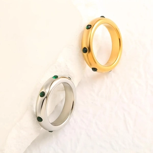 Détail de bagues minimalistes en or 18 carats et argent avec pierres vertes rondes