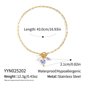 Macro view of stainless steel toggle clasp necklace with ceramic heart and pearl pendant