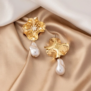 Detail of gold floral earrings with baroque pearls and sparkling crystals on silk
