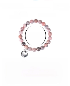Macro view of pink zebra stone beaded bracelet with apple charm and size specifications