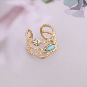 Gros plan détaillé d'une bague multicouche dorée avec pierre turquoise et zircons