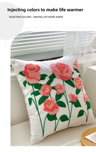 Close-up of pink tulip floral embroidery and tufted texture on a white cushion cover