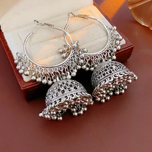Detailed macro view of silver ethnic Jhumka earrings with intricate bell tassels