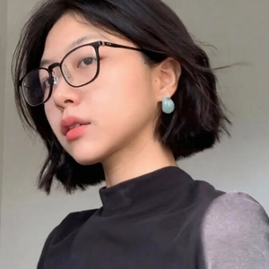 Boucles d'oreilles minimalistes en résine vert clair portées par un mannequin à lunettes