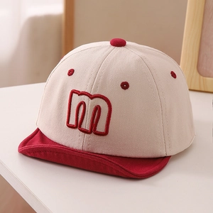 Detailed close-up of the letter M embroidery on a two-tone cotton baby baseball cap