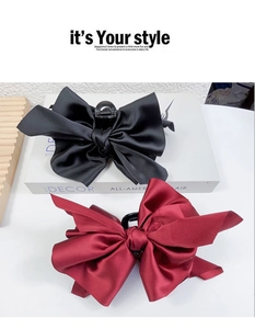 Detail of large black and burgundy satin bow hair claws with elegant silk texture